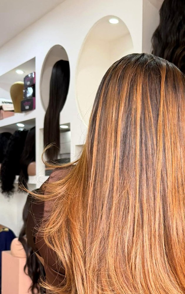 Le showroom MALIA HAIR à Conakry — mur de perruques et têtes de présentation